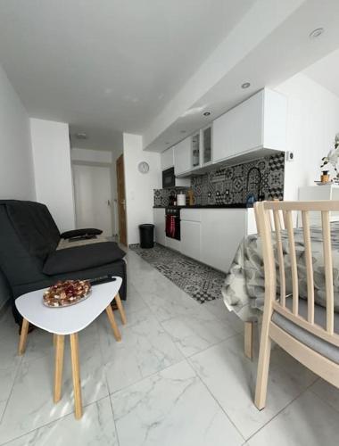 uma sala de estar com um sofá e uma mesa em Appartement 2 pièces RDC em Rambouillet
