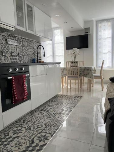 Il comprend une cuisine équipée d'une cuisinière et d'une salle à manger. dans l'établissement Appartement 2 pièces centre-ville, à Rambouillet