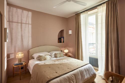 une chambre avec un lit et une grande fenêtre dans l'établissement Marais - 4 pièces de 115 m2 - grand salon convivial, à Paris