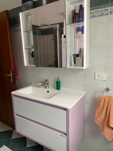 La salle de bains est pourvue d'un lavabo blanc et d'un miroir. dans l'établissement Opera Apartments, à Monterenzio