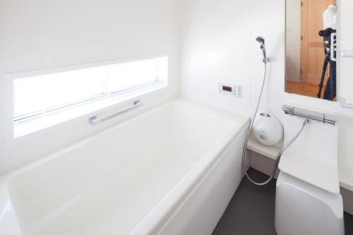 biała łazienka z oknem i umywalką w obiekcie 南葉山 - Seaside Cabin in Minami-hayama w mieście Hayama