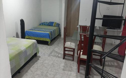 - une chambre avec 2 lits et un bureau avec une télévision dans l'établissement Apartamento amoblado 302, à San Luis