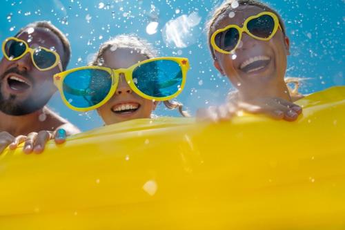 a group of three children wearing sunglasses in the water at Camping Village Le Calanchiole in Capoliveri