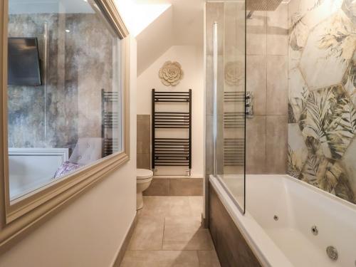 uma casa de banho com um chuveiro, uma banheira e um WC. em The Swans Nest Lock View em Skipton