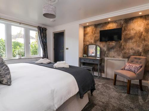 um quarto com uma cama e uma televisão na parede em The Swans Nest Lock View em Skipton