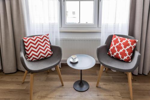 dwa krzesła i stół przed oknem w obiekcie Gasthof Zum Roten Haus 