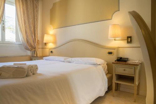 a hotel room with two beds and a window at Ena Hotel in Arenzano