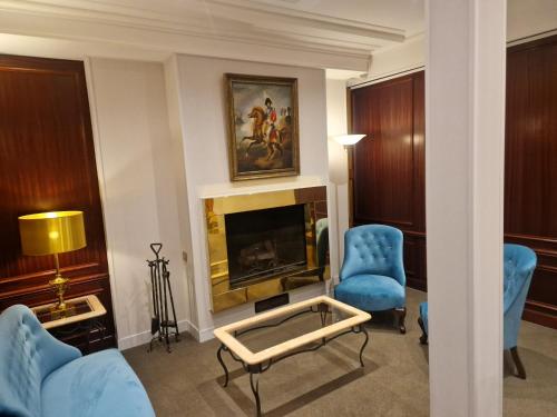 برينسس كارولين في باريس: غرفة معيشة مع كراسي زرقاء ومدفأة