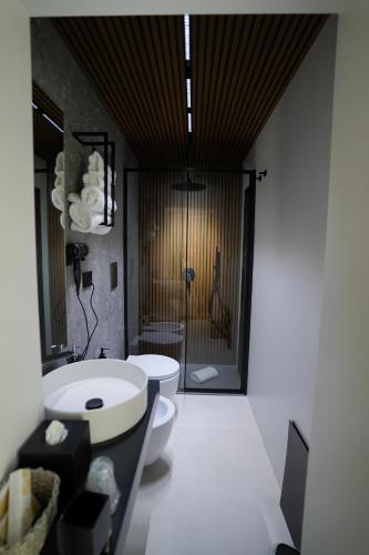 a bathroom with a toilet and a sink and a shower at Barneys B&b in Cercola