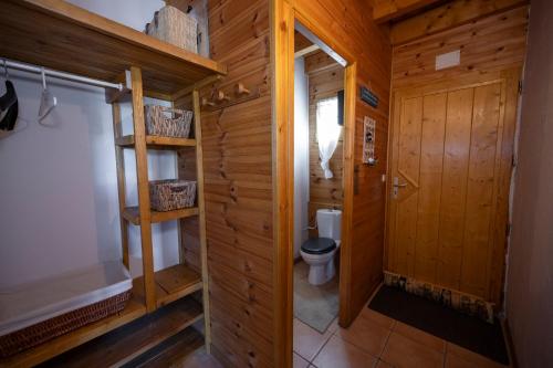 La salle de bains est pourvue de toilettes et d'un mur en bois. dans l'établissement Parenthèse Alpine - Poêle à bois - Calme - Parking, à Enchastrayes
