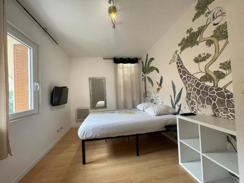 - une chambre avec un lit orné d'une fresque murale représentant des girafes dans l'établissement 3 Apparts à la même adresse, à Villard-Bonnot
