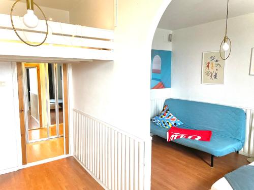 sala de estar con sofá azul y cama elevada en Small home in Kamppi, en Helsinki