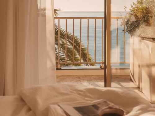 a bedroom with a view of the ocean from a balcony at Soleil Riviera Apartament Côte d’Azur in Roquebrune-Cap-Martin