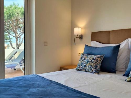 - une chambre avec un lit et une vue sur une terrasse dans l'établissement Albufeira Sol Villas V - Pool and Garden & Gym & SPA, à Albufeira