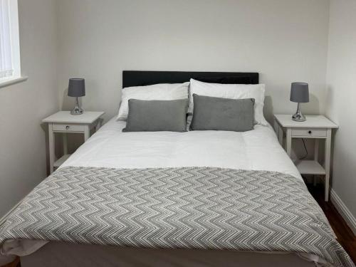 a bedroom with a bed with two nightstands and two lamps at Manchester flat close to City Centre and Stadium in Manchester