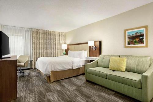 une chambre d'hôtel avec un lit et un canapé dans l'établissement Hampton Inn Findlay, à Findlay
