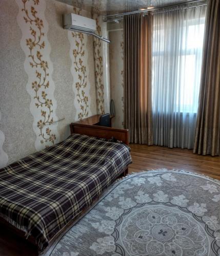a bedroom with a bed and a rug and a window at Apartment near the airport - Квартира около аэропорта in Dushanbe