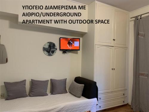 a bedroom with a bed with a tv on the wall at Rivitel Marousi Apartments in Athens