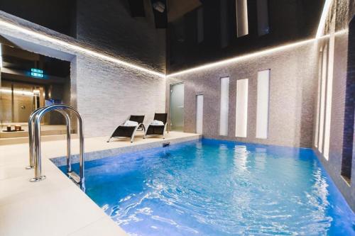 a bathroom with a tub and a swimming pool at Hotel Weneda in Opole