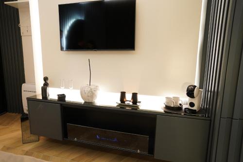 a black entertainment center with a tv on a wall at Barneys B&b in Cercola