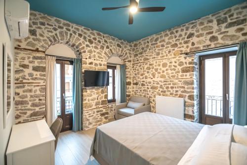 una camera da letto con un letto e un muro di pietra di Marquesa Boutique Hotel a Nafpaktos