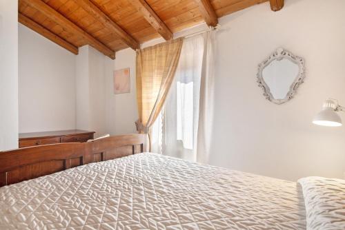 a bedroom with a bed and a mirror and a window at Ca' du Re in Chiavari