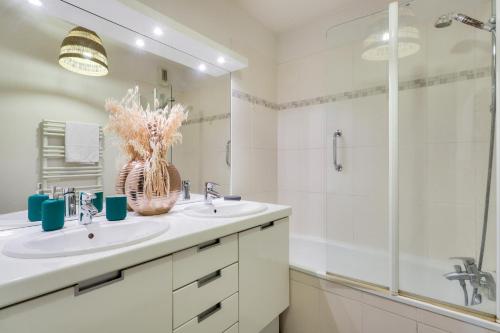 une salle de bain blanche avec un lavabo et une douche dans l'établissement Séjour sur l'île de Nantes avec vue sur la Loire, à Nantes