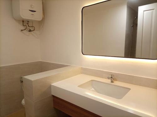 a bathroom with a sink and a large mirror at Selat Sunda Beautiful in Carita