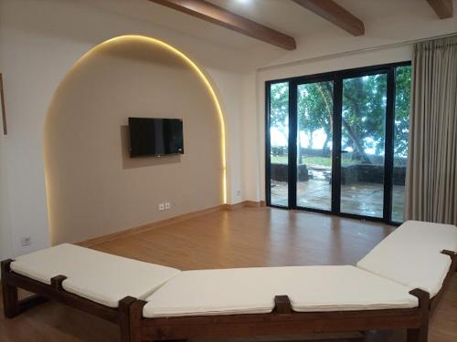 a living room with a bed and a large window at Selat Sunda Beautiful in Carita