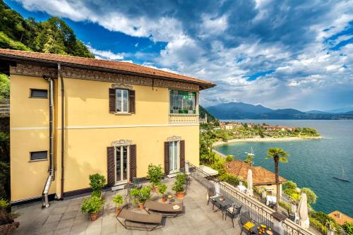 a house with a balcony overlooking a body of water at Hotel La Rondinella in Cannero Riviera