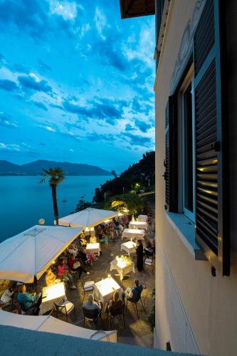 a group of tables and chairs with a view of the water at Hotel La Rondinella in Cannero Riviera