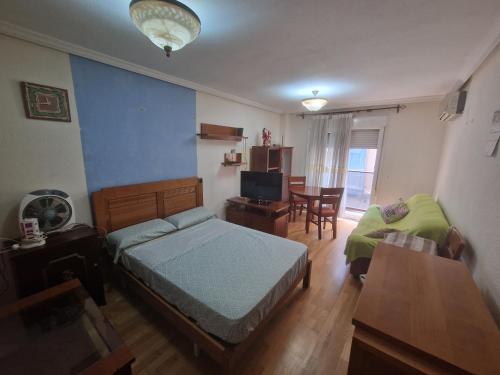 a bedroom with a bed and a table and a chair at Casa Linda in Alicante