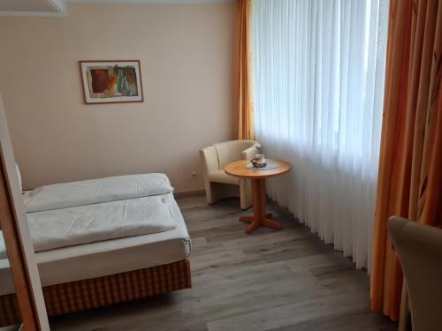 a room with a bed and a table and a window at Hotel Stadt Witzenhausen in Witzenhausen