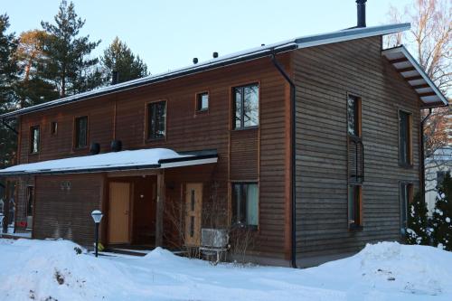 een houten huis met sneeuw ervoor bij Villa Rauhan Helmi in Lappeenranta