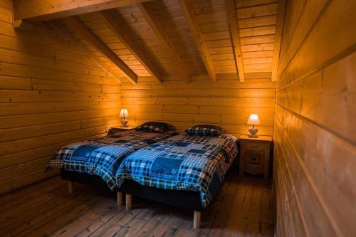 a bedroom with a bed in a wooden cabin at Chalet du Liesthal in Obersteinbach