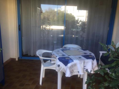 einen Tisch und einen Stuhl in einem Zimmer mit Fenster in der Unterkunft Les Naïades in Balaruc-les-Bains