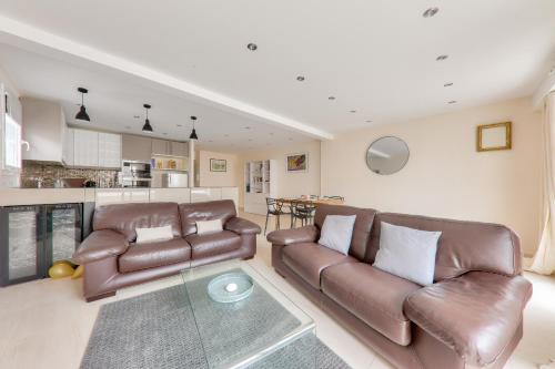 a living room with two leather couches and a glass table at Séjour apaisant au coeur de Sarzeau in Sarzeau