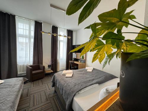 una habitación de hotel con 2 camas y una planta en Hotel Bregenz en Berlín