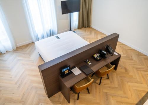 a bedroom with a bed and a desk with two chairs at Parkhotel Kortrijk in Kortrijk