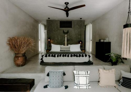 a bedroom with a bed and a couch at Hotel Bardo - Adults Only in Tulum