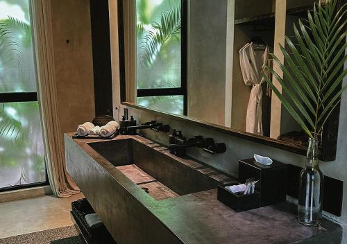 a bathroom with a sink and a large mirror at Hotel Bardo - Adults Only in Tulum