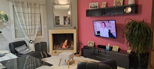 een woonkamer met een roze muur en een open haard bij Séjour inoubliable en Normandie Maison avec Spa in Valognes