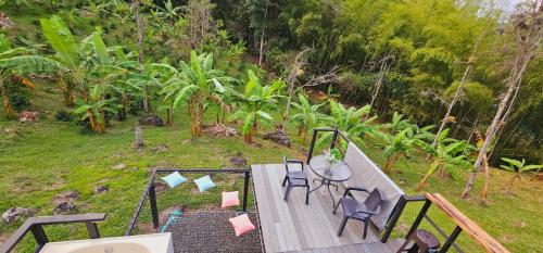 an aerial view of a table and chairs on a deck at Glamping y Cabañas Alpina in Buga