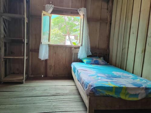 een bed in een kamer met een raam bij Casa los congos in Puntarenas