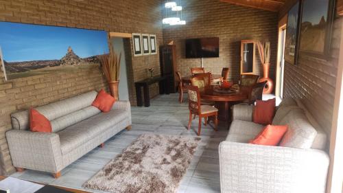 a living room with two couches and a dining room at Tripple N Guest Lodge in Ladybrand