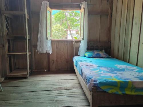 een kleine kamer met een bed en een raam bij Casa los congos in Puntarenas