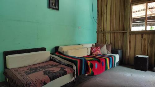 een woonkamer met een bank en een bed bij Casa los congos in Puntarenas
