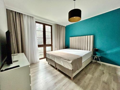 Sopot Marina Beach Suites في سوبوت: غرفة نوم بسرير وجدار ازرق