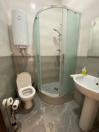 a bathroom with a shower and a toilet and a sink at Sweet2sleep in Kyiv