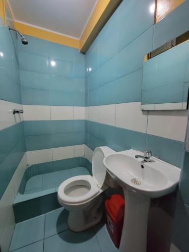 y baño con aseo y lavamanos. en Hospedaje Escorpio, en Lima